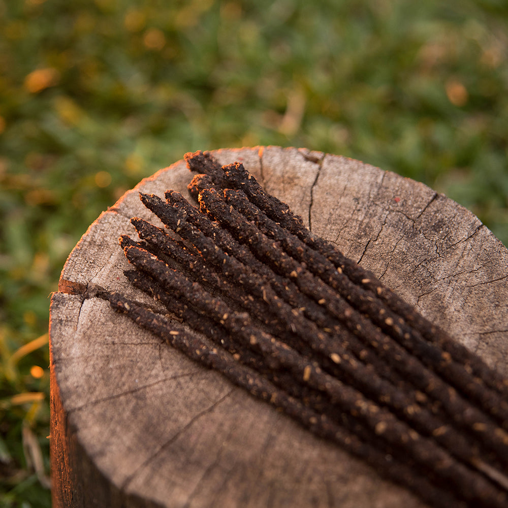 Close-up of a myrrh incense sticks against a blurred natural background.