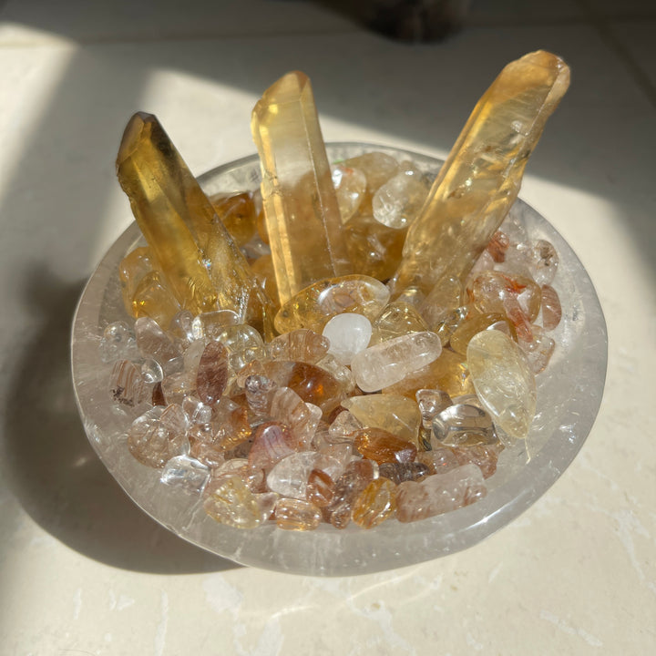 Abundance Bowl with natural Zambian Citrine, rutilated quartz chips and miniature Chinese Yuan Bao in a clear quartz bowl.