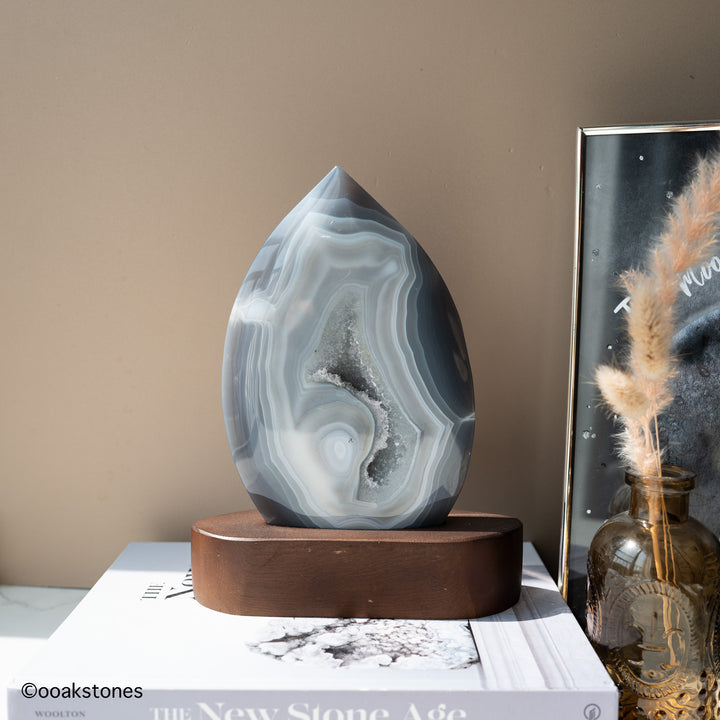 Blue-gray Madagascar agate flame sculpture with natural quartz cavity and wooden base