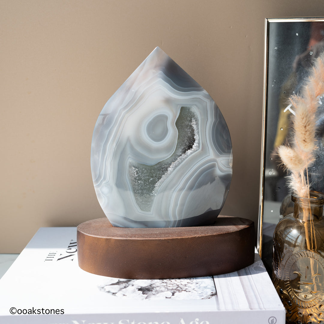 Natural gray agate flame with white concentric banding and crystalline quartz interior