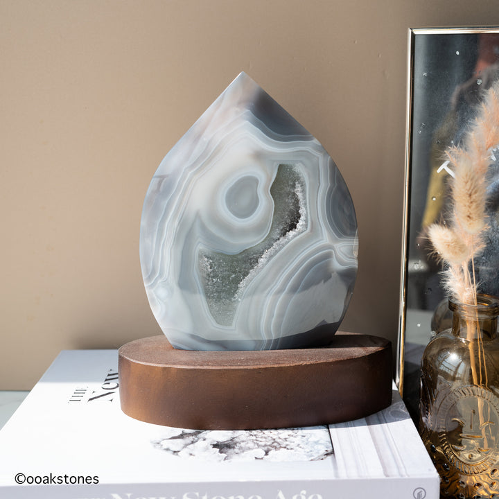 Natural gray agate flame with white concentric banding and crystalline quartz interior