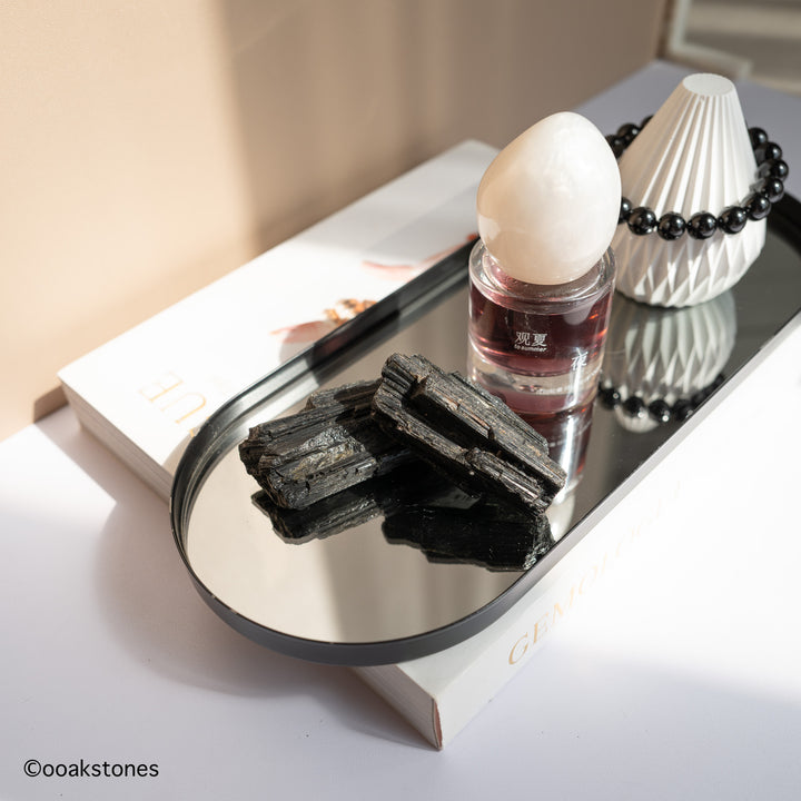 Natural raw Black Tourmaline crystal from Brazil displayed next to perfume