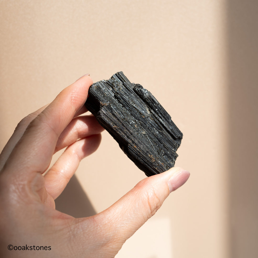 Natural raw Black Tourmaline crystal from Brazil held in hand