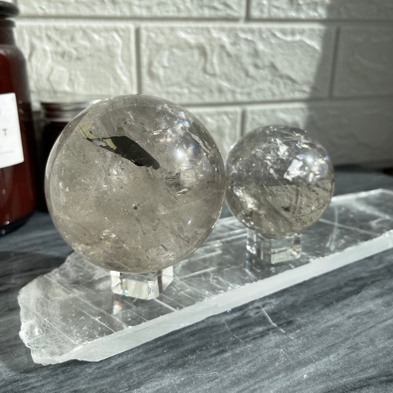2 Smoky quartz sphere sitting on a selenite plate