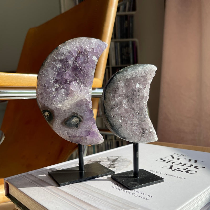 Amethyst moon on stand placed on books