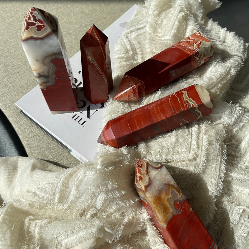 Red Jasper crystal point display on top of books and fabrics